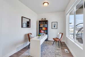 Office space featuring visible vents, baseboards, and dark wood-style floors