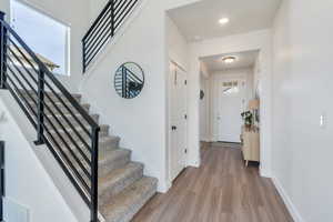 Interior space with visible vents, recessed lighting, stairway, wood finished floors, and baseboards
