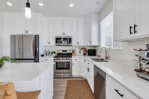 Kitchen featuring a sink, white cabinets, and stainless steel appliances