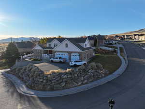 Exterior space featuring concrete driveway, a residential view, a mountain view, and a garage