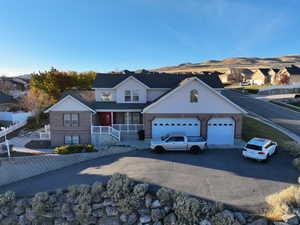 View of front of home with aphalt driveway, fence, brick siding, an attached garage, and a mountain view