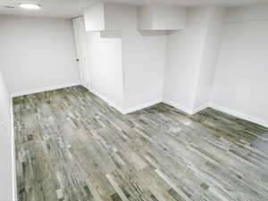 Finished below grade area with baseboards and wood finished floors