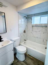 Full bathroom with vanity, bathtub / shower combination, toilet, and wood finished floors