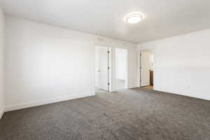 Carpeted empty room with visible vents and baseboards