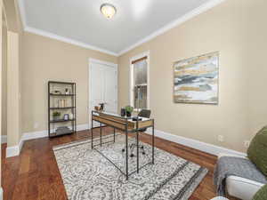 Office area featuring ornamental molding, baseboards, and wood finished floors