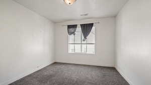 Unfurnished room featuring visible vents, baseboards, a textured ceiling, and carpet floors