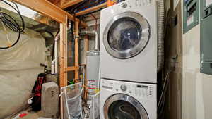 Clothes washing area featuring gas water heater, stacked washer / dryer, and laundry area