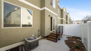 View of home's exterior with cooling unit, a residential view, stucco siding, and fence