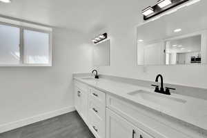 Basement bathroom with double sinks & a shower/tub combo