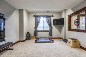 Exercise area featuring carpet flooring and baseboards