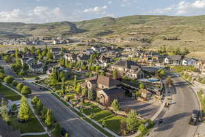 Aerial view of property and surrounding area featuring nearby suburban area and mountains