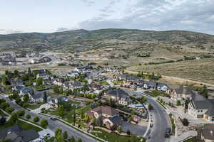 Aerial view of property and surrounding area with nearby suburban area and mountains