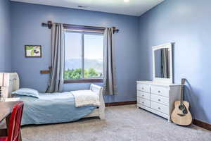 Carpeted bedroom with baseboards and a mountain view