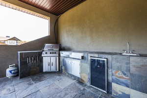 View of patio featuring beverage cooler and an outdoor kitchen