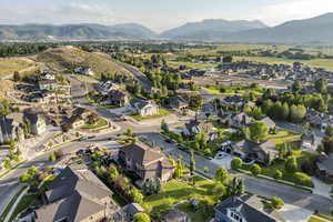 Aerial view of property and surrounding area with a mountainous background and nearby suburban area