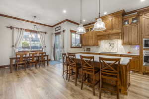 Kitchen with light countertops, a kitchen island, brown cabinetry, recessed lighting, and healthy amount of natural light