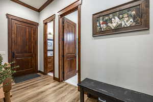 Entryway featuring crown molding and light wood-style flooring