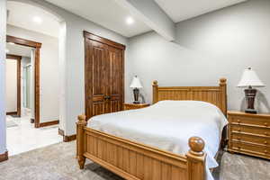 Bedroom featuring light carpet, arched walkways, and recessed lighting