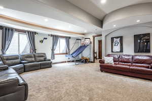 Carpeted living area with recessed lighting and lofted ceiling
