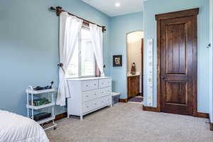 Bedroom featuring carpet, arched walkways, connected bathroom, and recessed lighting
