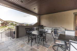 View of patio / terrace with outdoor dining space, an outdoor kitchen, and beverage cooler
