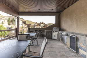 View of patio / terrace with outdoor dining area, wine cooler, and exterior kitchen