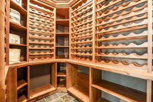 Wine area with a sauna / steam room and stone finish floors