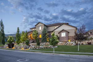 View of front of property featuring stone siding and a front yard