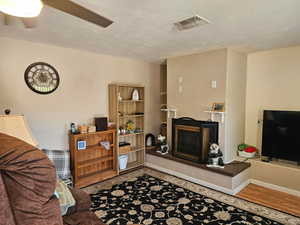 Living area with a fireplace and wood finished floors