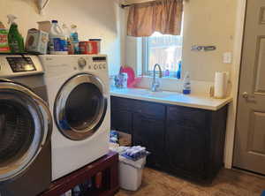 Laundry area with washing machine and clothes dryer and light tile patterned flooring