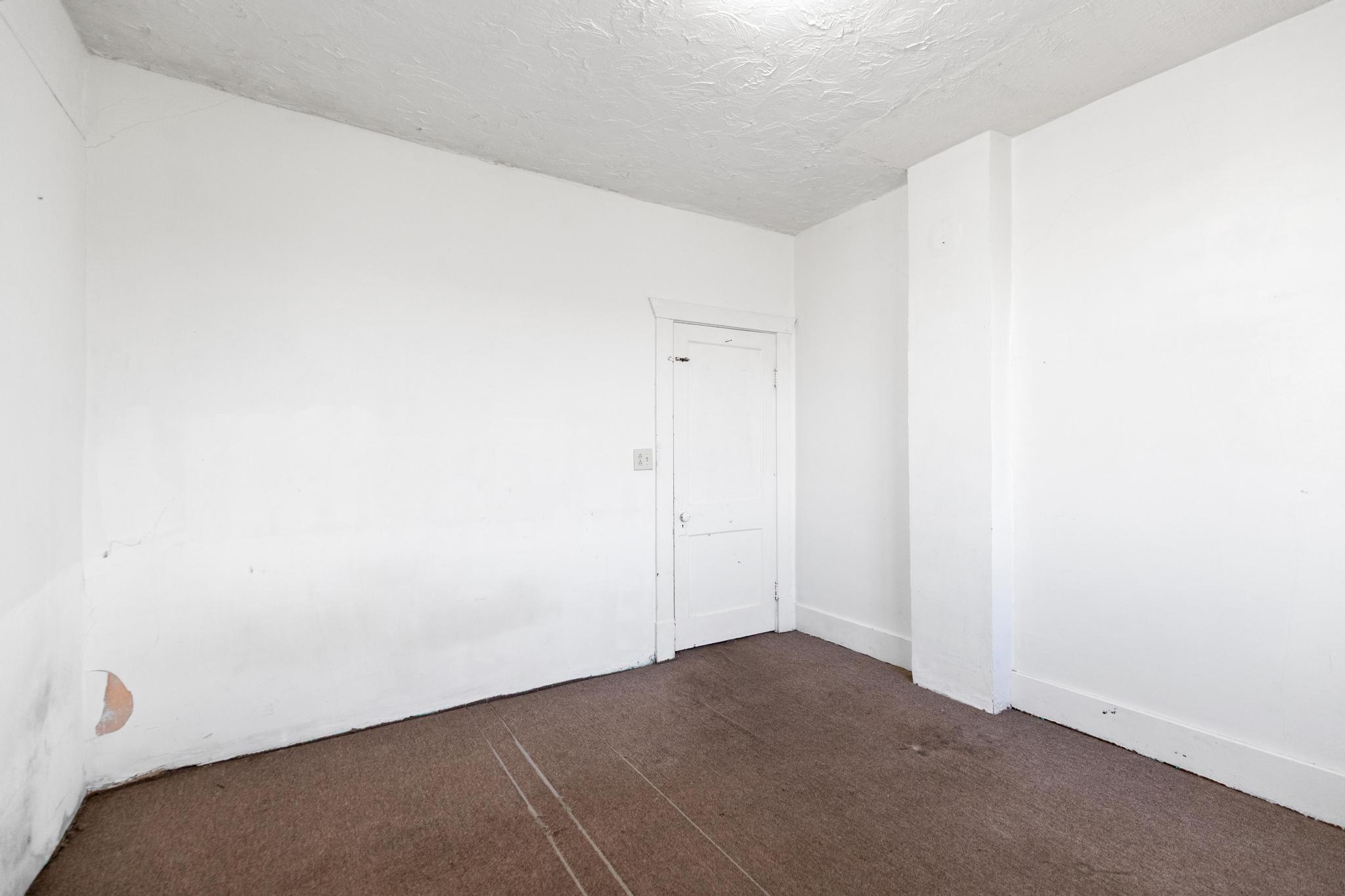 Empty room featuring dark colored carpet and a textured ceiling