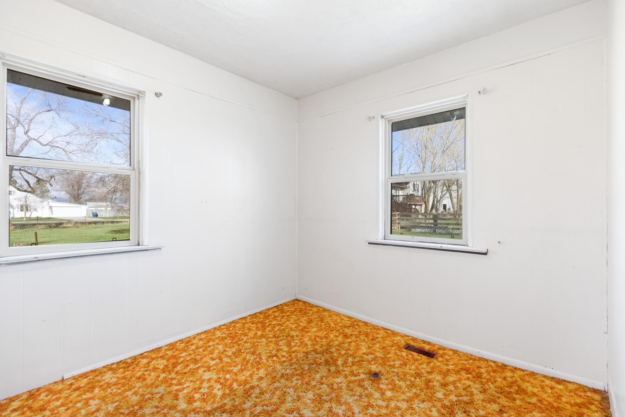 Carpeted empty room featuring a wealth of natural light, visible vents, and baseboards
