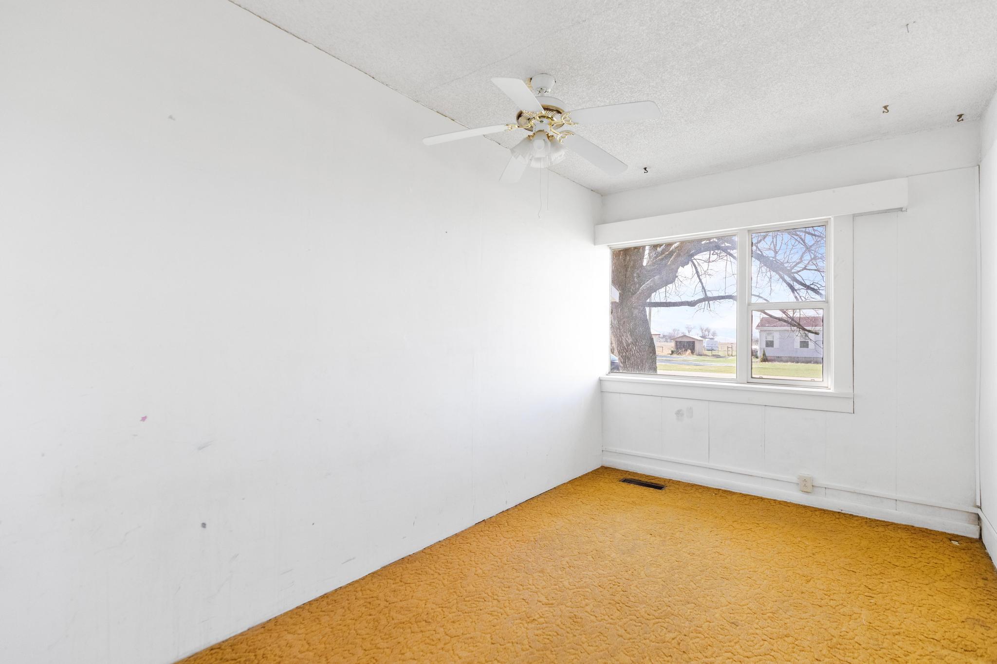 Spare room with a textured ceiling, visible vents, ceiling fan, and light colored carpet