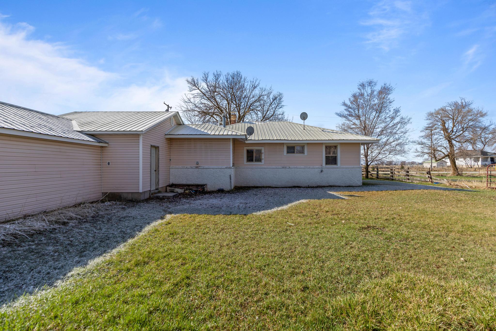 Rear view of property with a lawn and metal roof