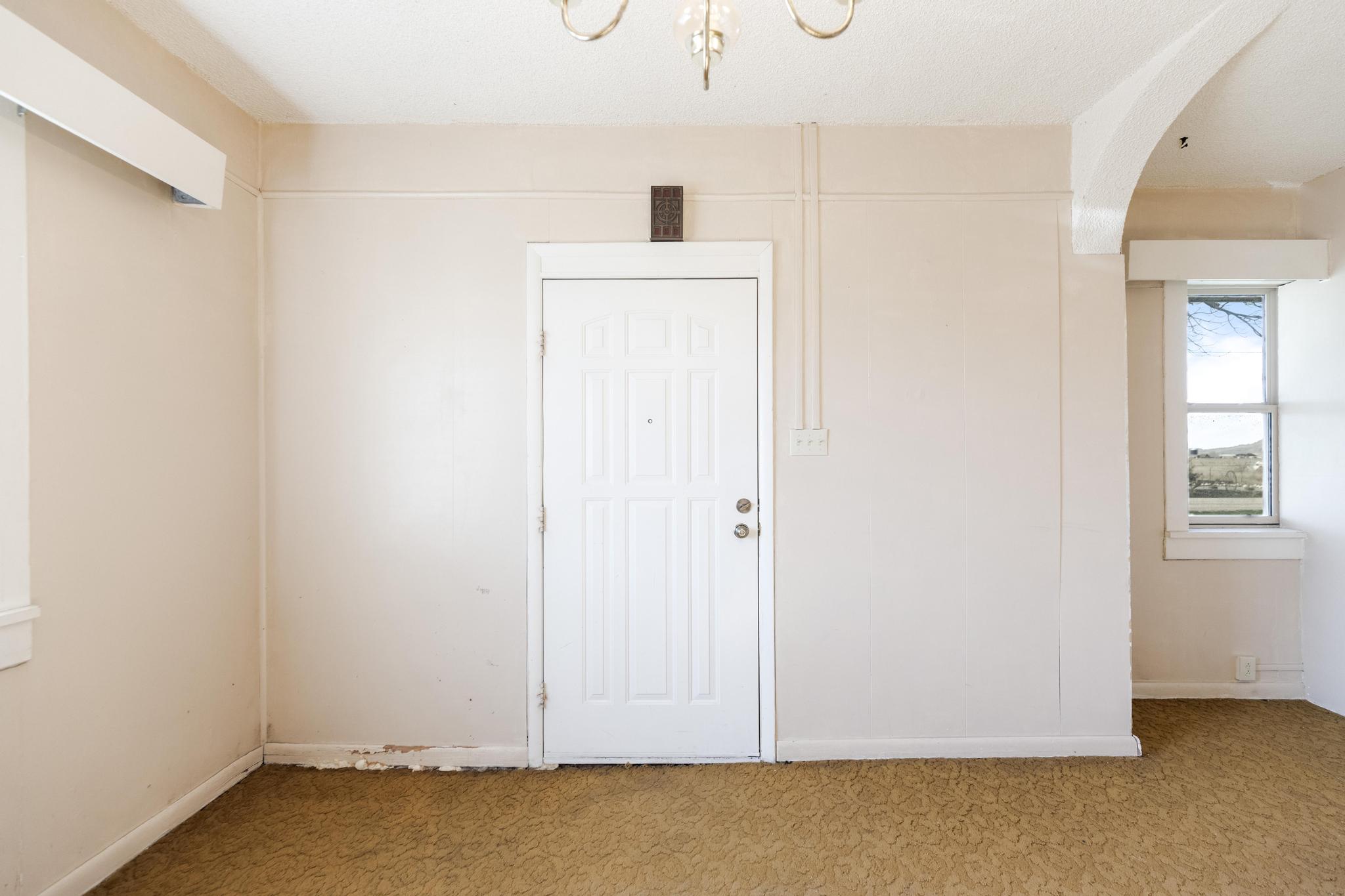 Empty room with light carpet and arched walkways
