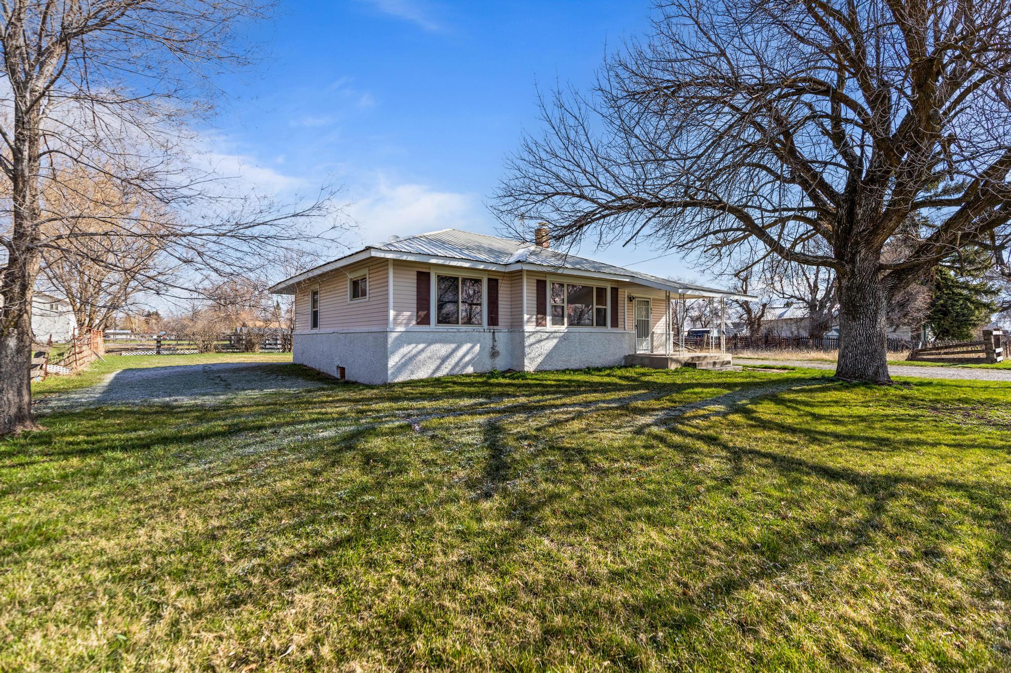 View of front facade with metal roof and a front lawn