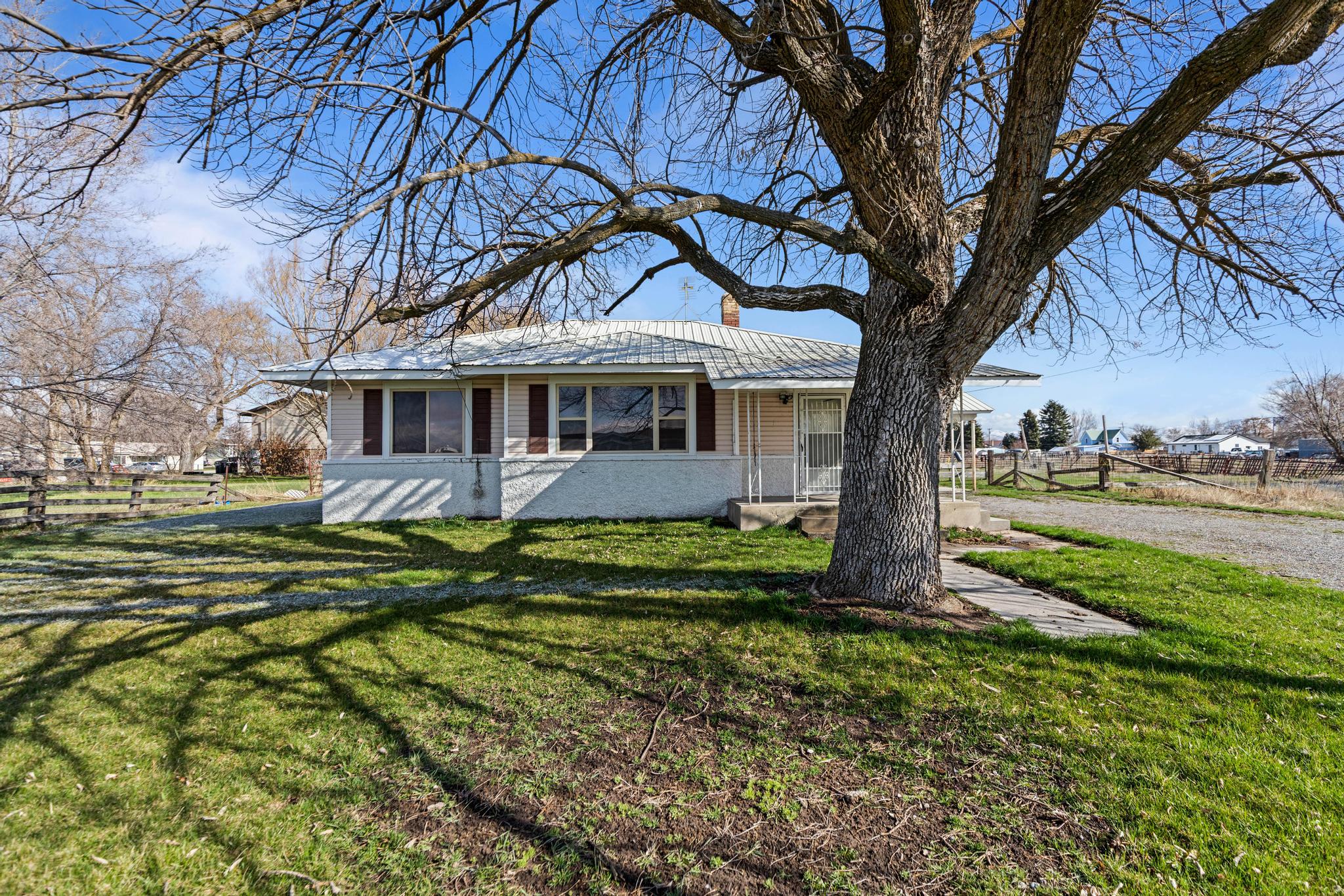View of front of property with metal roof, fence, a chimney, and a front yard