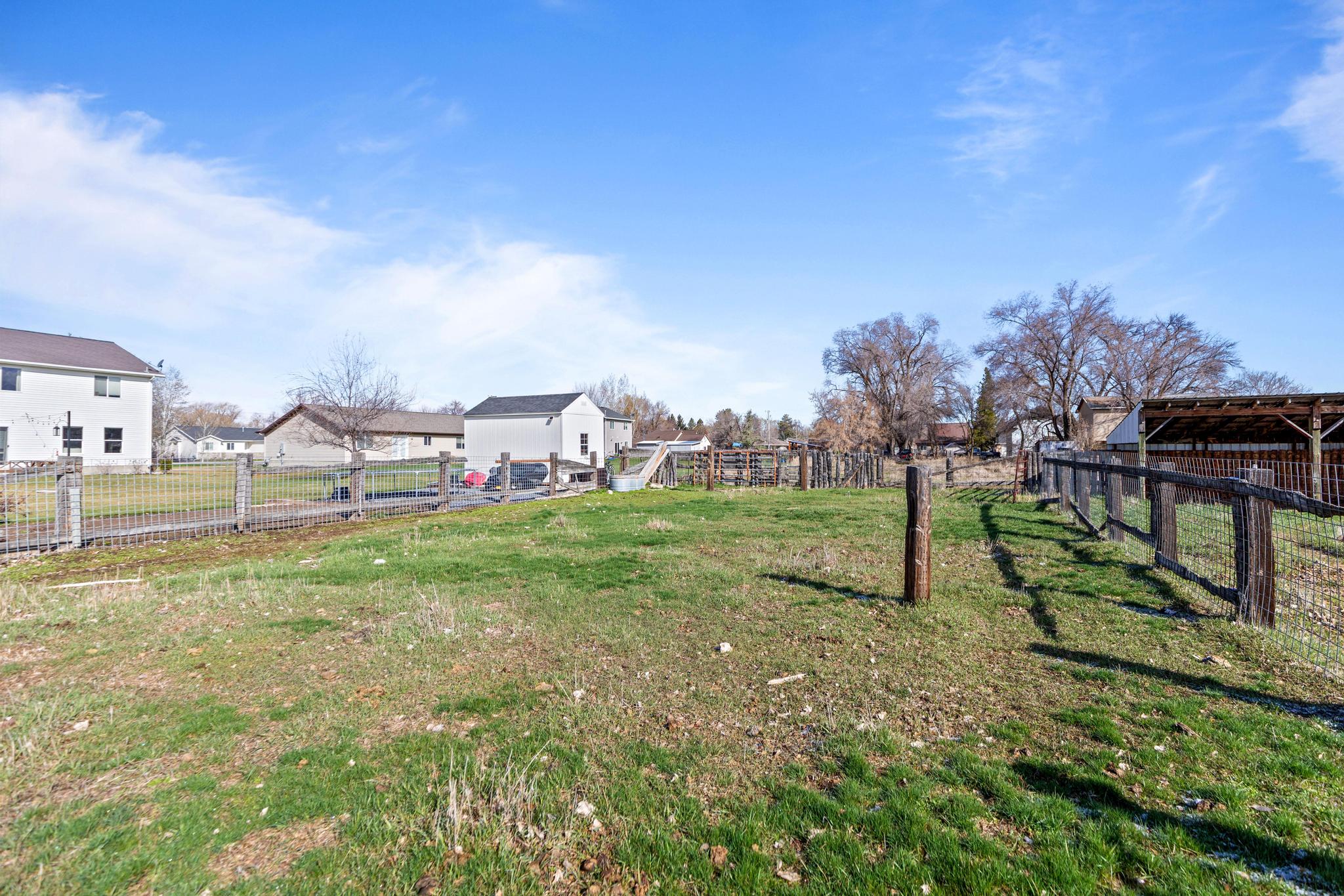 View of yard featuring a residential view, an outdoor structure, and fence