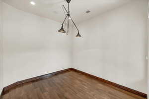 Unfurnished dining area featuring baseboards, dark wood-style floors, visible vents, and recessed lighting