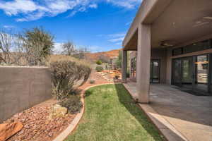 View of yard featuring fence, a patio, and a ceiling fan