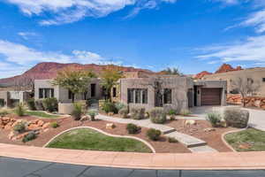 Southwest-style home featuring an attached garage, driveway, stucco siding, and a mountain view