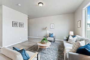 Living room with wood finished floors, baseboards, and visible vents