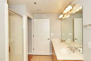 Bathroom with a sink, tile patterned flooring, and visible vents
