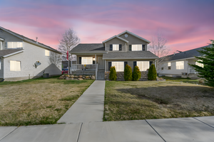 View of front of house with a front yard, stone siding, and covered porch