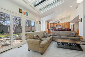 Living room with visible vents, an inviting chandelier, recessed lighting, high vaulted ceiling, and light colored carpet