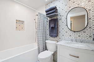 Bathroom with shower / tub combo with curtain, vanity, and toilet