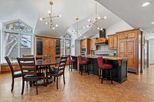 Dining area featuring high vaulted ceiling, recessed lighting, a textured ceiling, and an inviting chandelier
