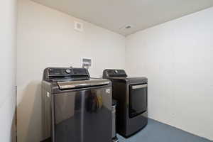 Laundry area featuring washer and dryer, laundry area, and visible vents