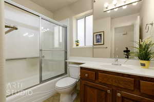 Bathroom featuring vanity and enclosed tub / shower combo