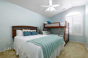 Carpeted bedroom featuring lofted ceiling and ceiling fan